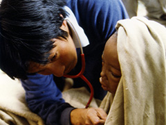 エチオピア大干ばつでの避難民への救援活動。飢餓状態で訪れた子供を診察する代表の仲佐（1985年）